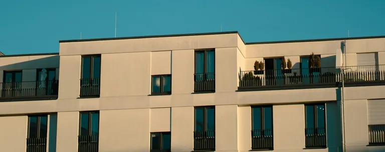 Mehrfamilienhaus vor blauem Himmel