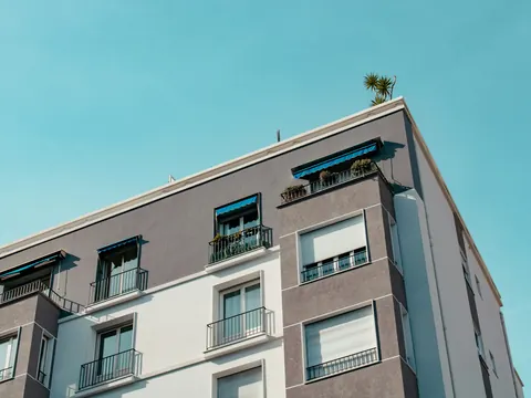 Wohnhaus mit Balkonen vor blauem Himmel